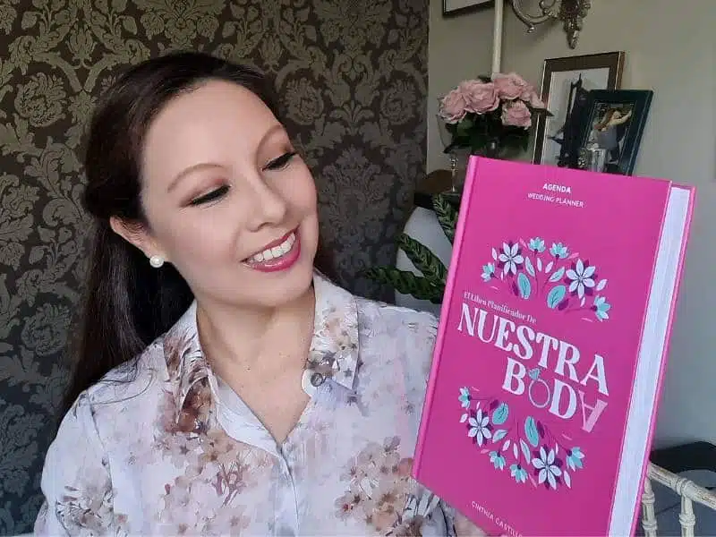 Autora mostrando el libro y agenda de planificación de bodas